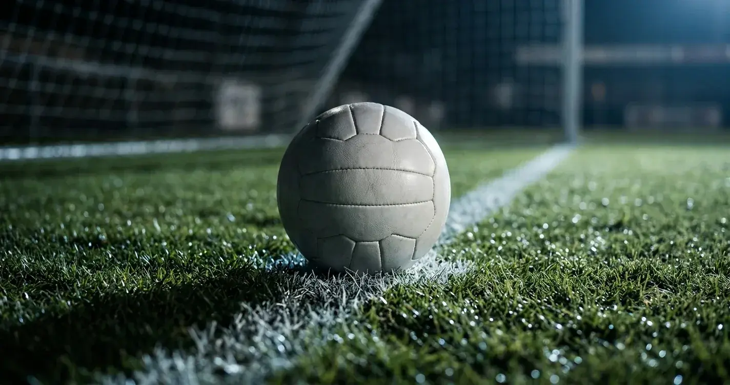 Fodbold på pletten i et tomt måls skygge på en kridtstribet bane